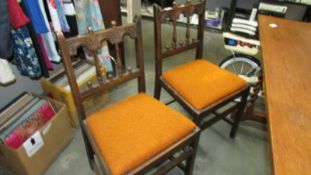 A set of four oak Gothic style dining chairs.