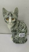 A signed pottery cat with glass eyes.