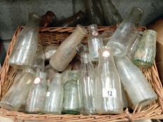 A wicker basket full of various milk bottles