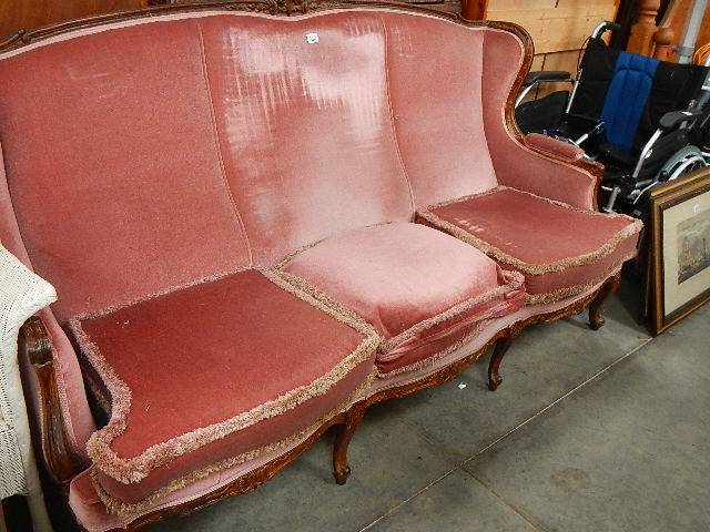 An old mahogany framed three seater sofa.