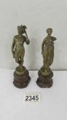 A pair of small bronze figures on marble bases (female missing an arm).