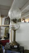 A Victorian oil lamp of pot base with brass column, hand painted font and acid edged shade.