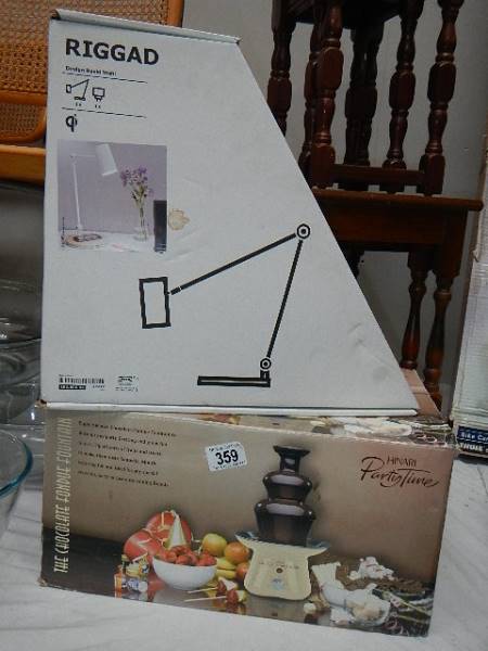 A boxed chocolate fountain and a boxed table lamp.