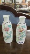 A pair of opaque hand painted glass vases (chip to rim on one).