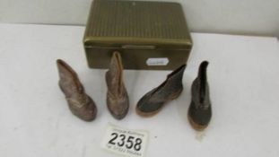 Two pairs of miniature leather shoes (possibly traveller's samples) in a metal box.