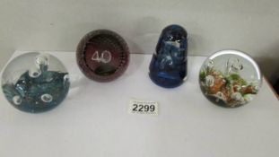 Four Caithness glass paperweights.