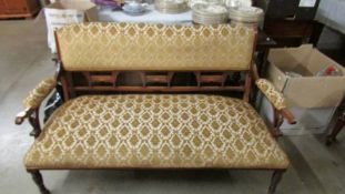 A mahogany framed sofa on casters.