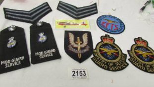 A selection of Ministry of Defence M.O.D guard service uniform badges etc.