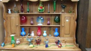 A large collection of vintage coloured glass ware including flowers, vases, Murano style etc.