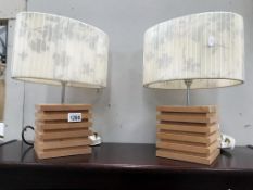 A pair of stylized wooden table lamps