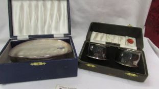 A cased pair of EPNS napkin rings and a cased silver plated hair brush.