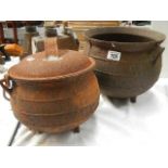 Two cast cauldrons (one has hole in bottom).
