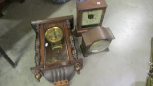 A wall clock and two mantel clocks.