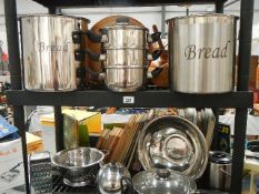 Two shelves of stainless steel kitchen ware.