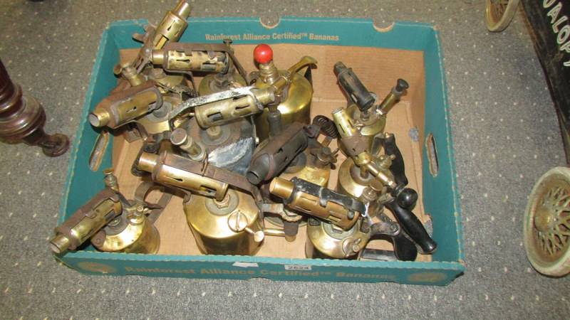 A box of old brass blow lamps.
