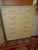 A cream 5 drawer chest.