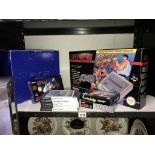 A PS2 PlayStation and a Super Nintendo system with selection of games