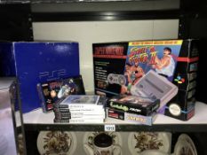 A PS2 PlayStation and a Super Nintendo system with selection of games