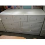 A white seven drawer chest.