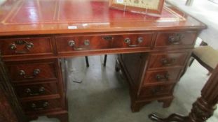 A mahogany double pedestal desk with red leather inset top.