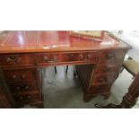 A mahogany double pedestal desk with red leather inset top.