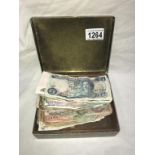 A brass tin of world bank notes