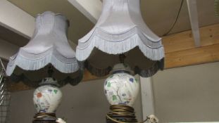 A pair of oriental style table lamps with fringed shades.