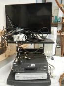 A television on stand with video and DVD player, in working order.