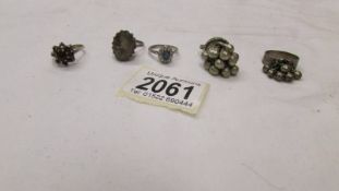 Five assorted rings including three silver.