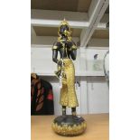 A detailed heavy bronze and gilt metal South East Asian standing figure on base.