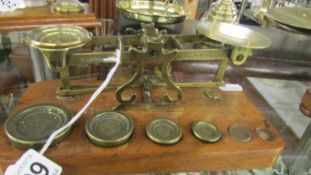 A set of brass postal scales with weights. S Morden, London, missing one weight.