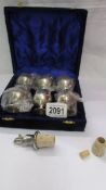 A cased set of 6 silver plate goblets and a wine bottle stopper.