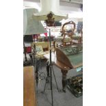 A wrought iron and copper standard lamp with shade.