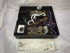 A box of costume jewellery including brooches & necklaces etc.