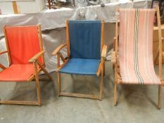 A deck chair and 2 other folding chairs.