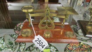 A set of brass postal scales with weights.