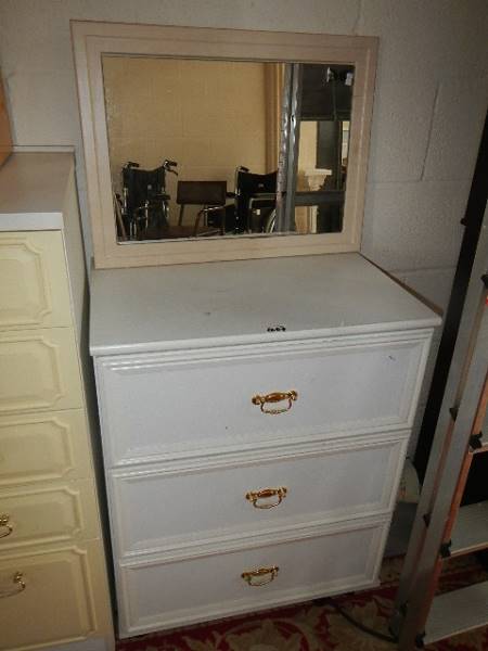 A white three drawer chest.