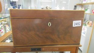 A figured mahogany tea caddy (missing inner lids).