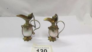 A pair of Victorian mother of pear and gilt metal scent bottle with chained stoppers.