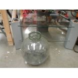 A TV table and a glass carboy.