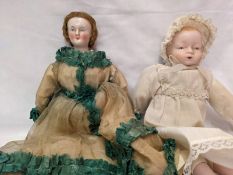 A Victorian wooden peg doll with porcelain head and a porcelain baby doll.