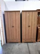 A pair of light oak effect melamine double door wardrobes with drawer,