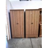 A pair of light oak effect melamine double door wardrobes with drawer,