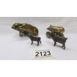 Two miniature bronze pigs and two brass pigs.