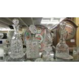 Three cut glass decanters and a glass candle lamp.