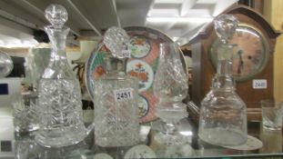 Three cut glass decanters and a glass candle lamp.