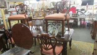 A mahogany extending dining table with three leaves and a set of 6 dining chairs.