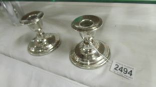 A pair of silver candlesticks, 8 cm tall.