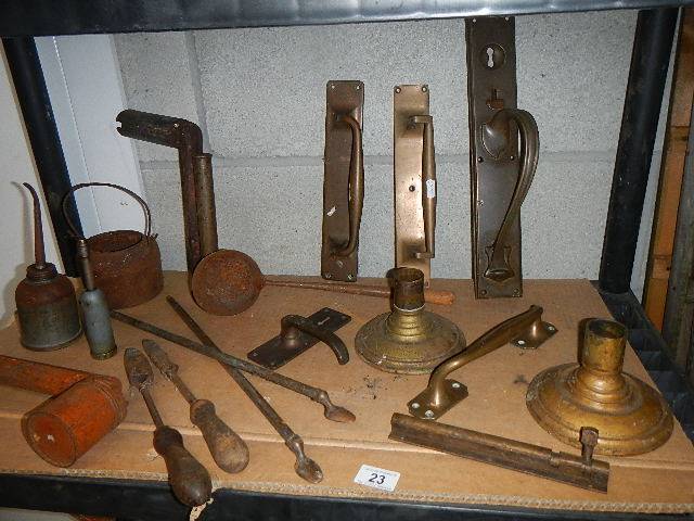 A shelf of assorted brass door handles and other architectural items.