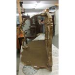 A free standing gilt framed corner mirror.